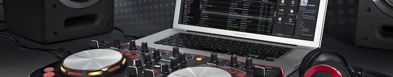 Un controlador DJ junto a un portátil con el programa Virtual DJ
