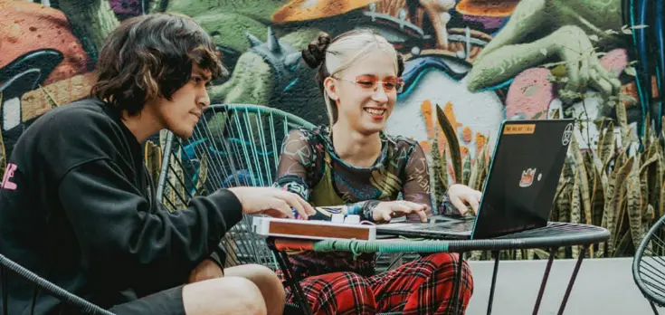 Un chico y una chica con un synth de Arturia y un ordenador